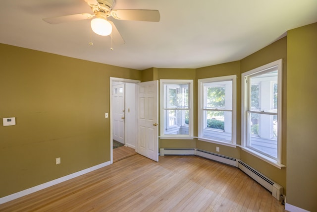 unfurnished room featuring baseboard heating, light hardwood / wood-style flooring, and ceiling fan