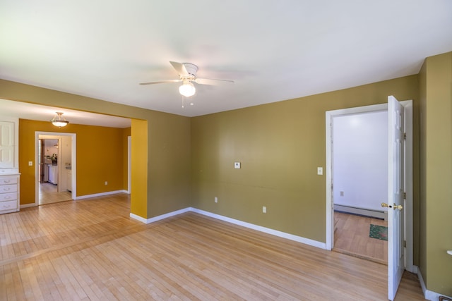 spare room with a baseboard radiator, light hardwood / wood-style floors, and ceiling fan