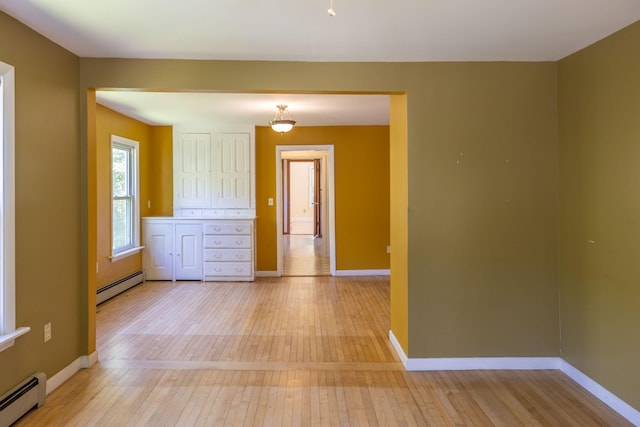 spare room featuring a baseboard radiator and light hardwood / wood-style floors