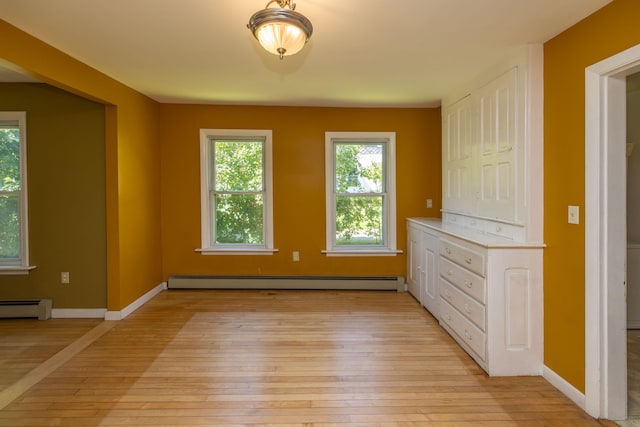 interior space with a closet, baseboard heating, and light hardwood / wood-style floors