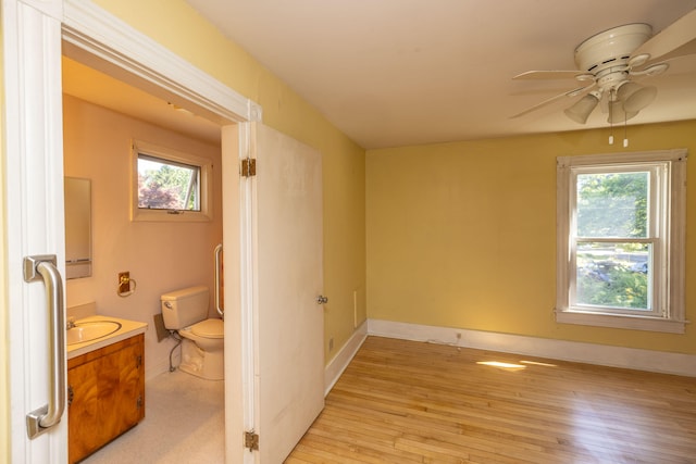 bedroom with light hardwood / wood-style flooring, ceiling fan, and sink