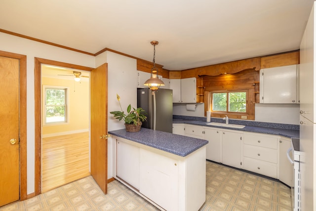 kitchen featuring decorative light fixtures, plenty of natural light, stainless steel refrigerator, and light hardwood / wood-style flooring