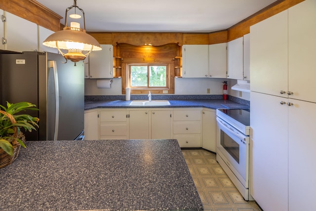 kitchen featuring white range with electric stovetop, sink, stainless steel fridge, and white cabinetry