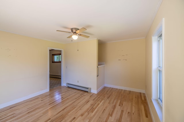 spare room featuring a baseboard heating unit, ceiling fan, plenty of natural light, and light hardwood / wood-style floors