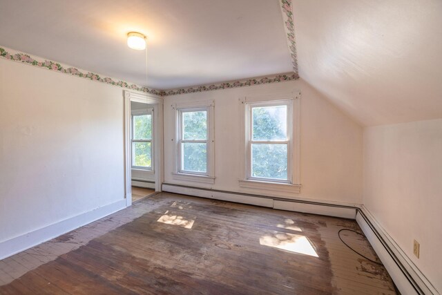 additional living space featuring lofted ceiling, baseboard heating, wood-type flooring, and a wealth of natural light