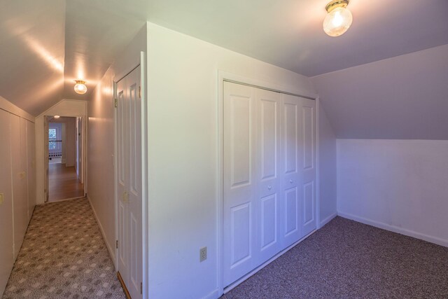 bonus room with vaulted ceiling and carpet floors