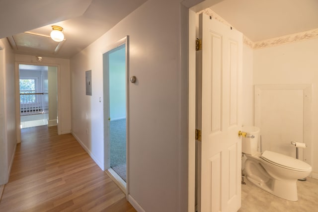 hallway featuring electric panel and light hardwood / wood-style flooring