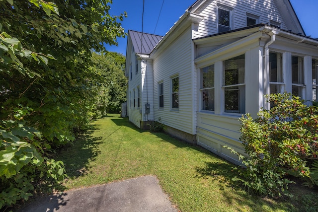 view of home's exterior featuring a yard and a sunroom