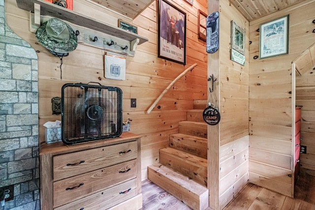 stairs featuring wood-type flooring, wood ceiling, and wooden walls