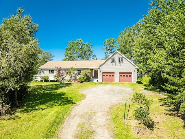 view of front of house with a garage, a front yard, and dirt driveway