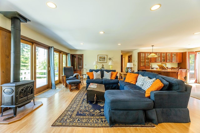 living room with light wood-type flooring, a wood stove, and recessed lighting