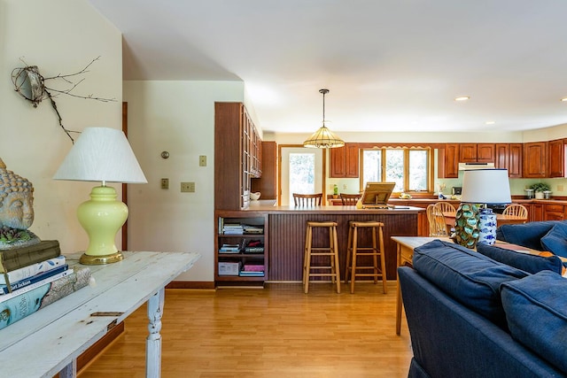 living room with baseboards, light wood finished floors, and recessed lighting