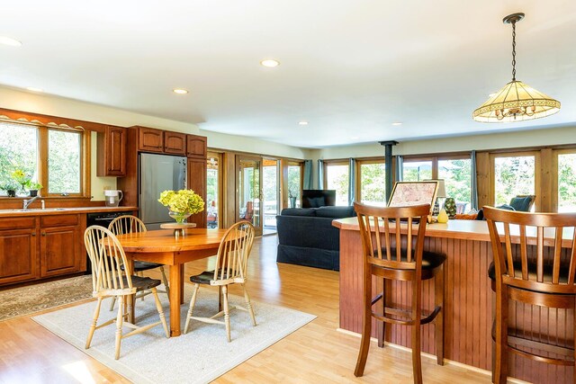 dining area with sink and light hardwood / wood-style floors