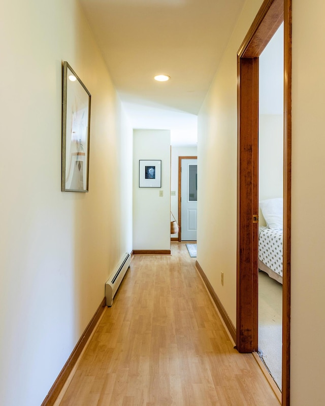 hall with light wood finished floors, baseboards, a baseboard heating unit, and recessed lighting