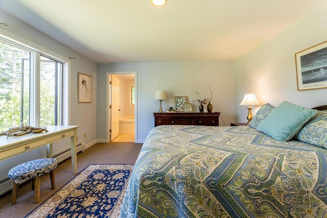 carpeted bedroom featuring a baseboard heating unit and ensuite bathroom