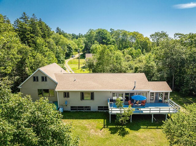 rear view of house with a wooden deck and a yard