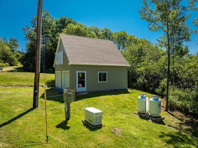 back of house featuring a garage and a lawn