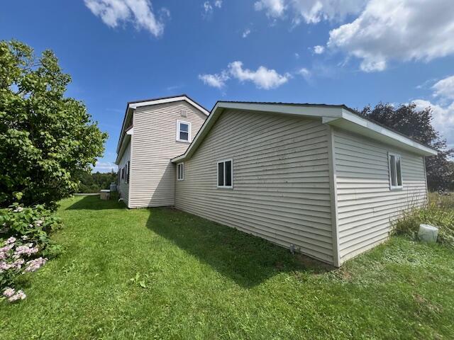 view of home's exterior with a lawn