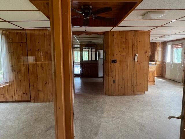 interior space with wood walls and a paneled ceiling