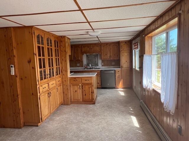 kitchen with wood walls, a baseboard radiator, and dishwasher