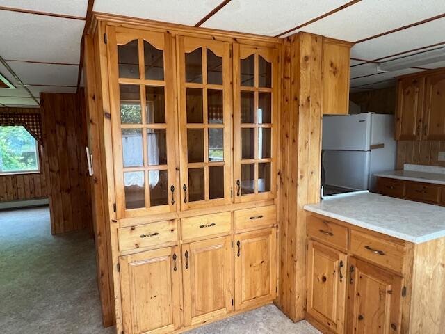 kitchen with white refrigerator, a wealth of natural light, and baseboard heating