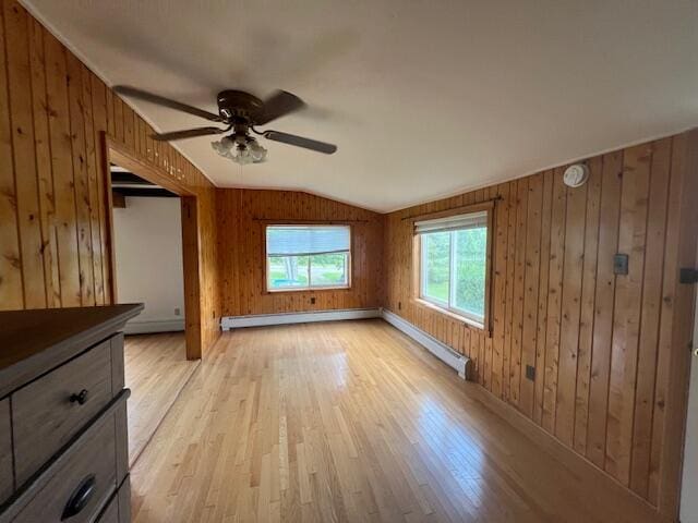 interior space featuring wooden walls, light wood-type flooring, and vaulted ceiling