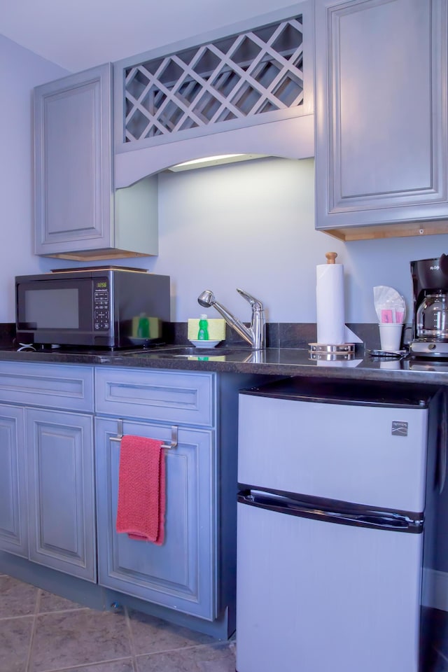 kitchen featuring light tile patterned floors and stainless steel refrigerator