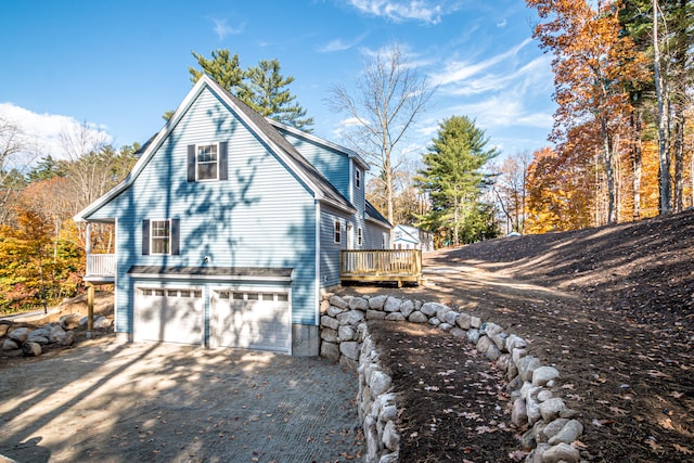 view of side of property with a wooden deck and a garage