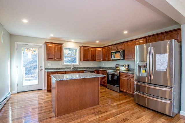 kitchen featuring a center island, appliances with stainless steel finishes, light wood-type flooring, and plenty of natural light