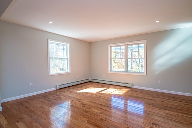 unfurnished room with hardwood / wood-style flooring and a wealth of natural light