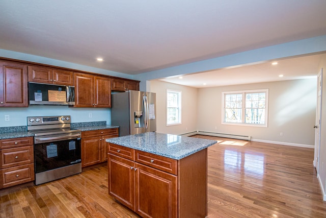 kitchen featuring a kitchen island, light hardwood / wood-style flooring, stainless steel appliances, light stone countertops, and a baseboard radiator