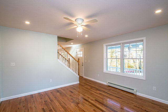 empty room featuring baseboard heating, wood-type flooring, and ceiling fan