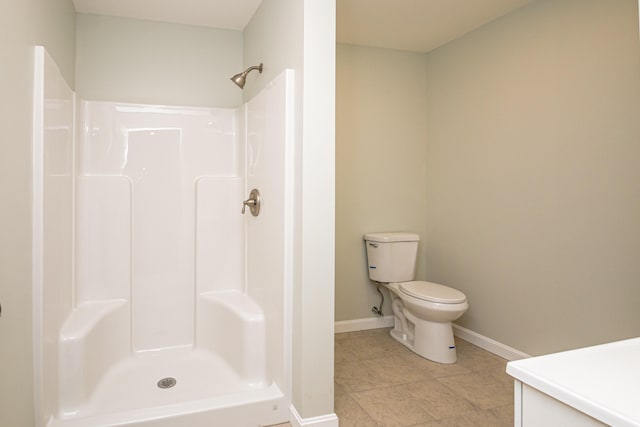 bathroom featuring toilet, walk in shower, vanity, and tile patterned flooring