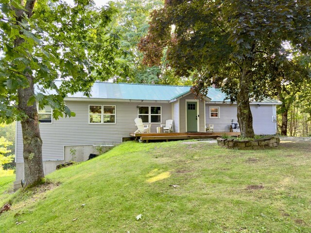 ranch-style house with a deck and a front lawn