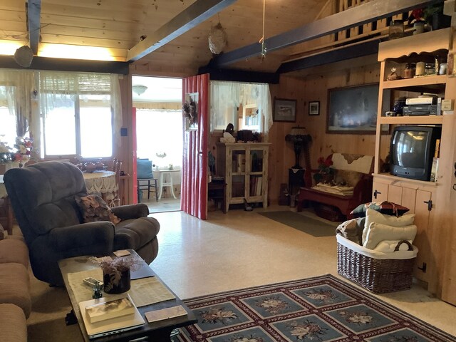 living room featuring wood walls, lofted ceiling with beams, and wooden ceiling