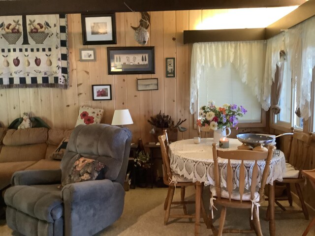 carpeted dining room with wooden walls