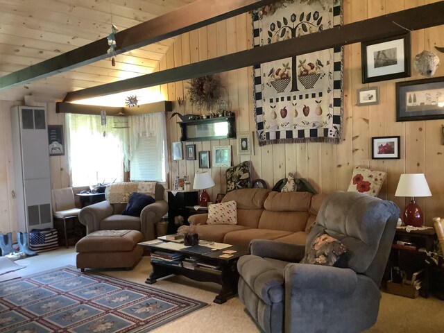 carpeted living room with lofted ceiling with beams and wooden walls