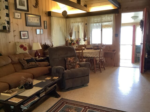 living room featuring wood walls and beamed ceiling