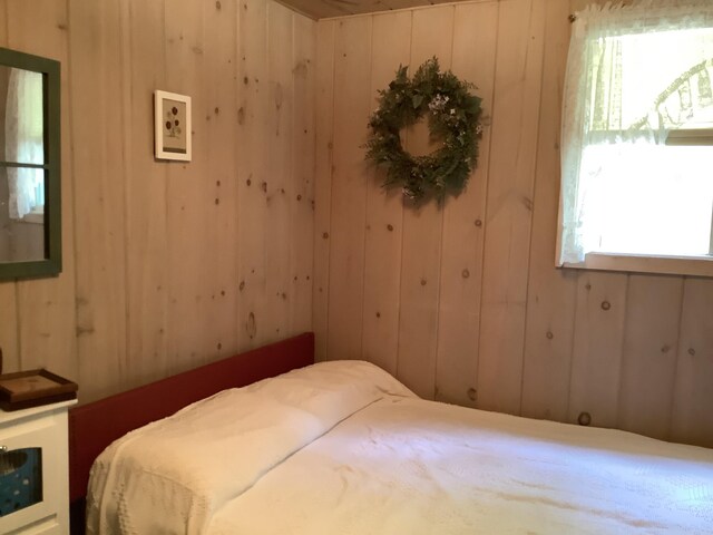 bedroom featuring wood walls