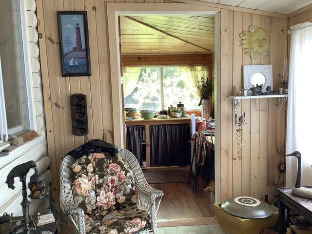 interior space with wood ceiling, a healthy amount of sunlight, wooden walls, and hardwood / wood-style flooring