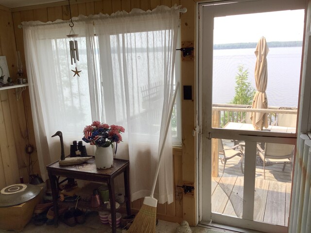 entryway featuring wooden walls and a water view