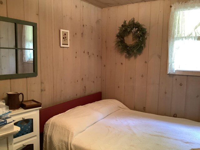 bedroom featuring wooden walls