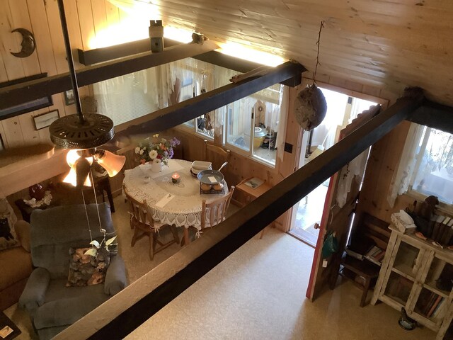 interior space featuring wood ceiling, lofted ceiling, ceiling fan, and carpet flooring