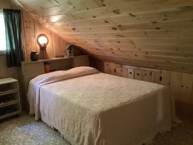 bedroom featuring wood walls, wooden ceiling, and vaulted ceiling