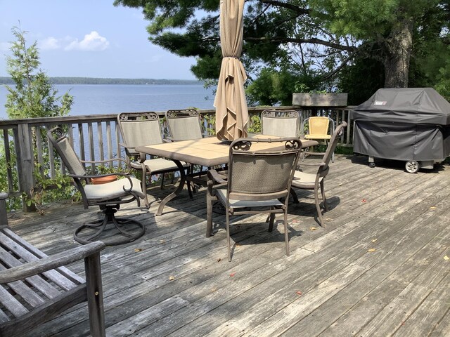 wooden deck featuring area for grilling and a water view