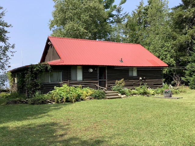 cabin featuring a front lawn