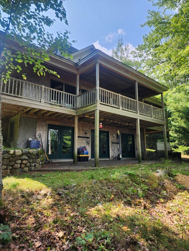 rear view of house featuring a balcony and french doors