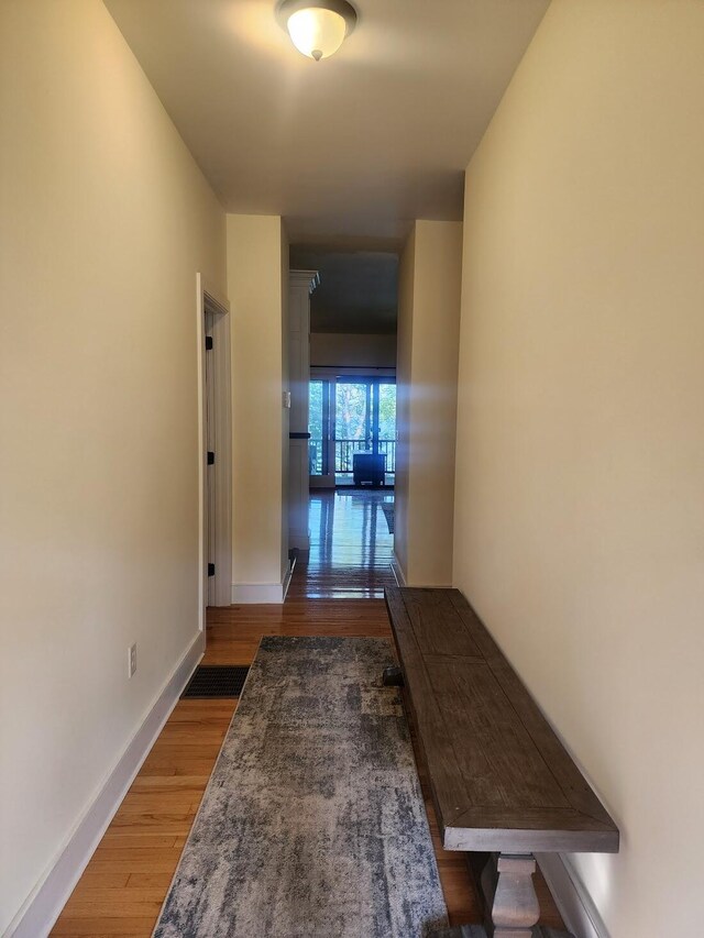 corridor with hardwood / wood-style flooring