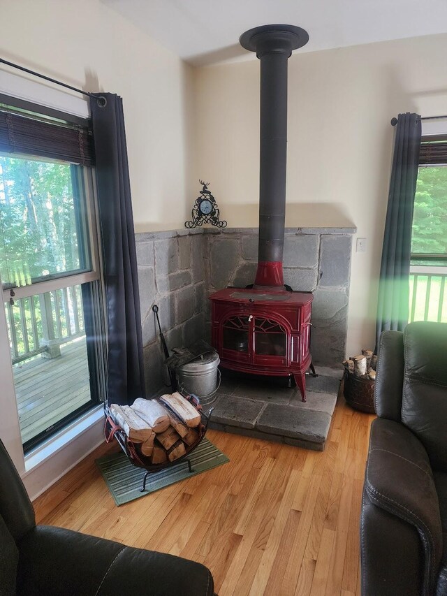 bedroom with light hardwood / wood-style floors and a wood stove