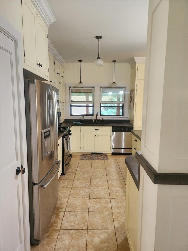 kitchen featuring light tile patterned flooring, stainless steel appliances, white cabinetry, and pendant lighting